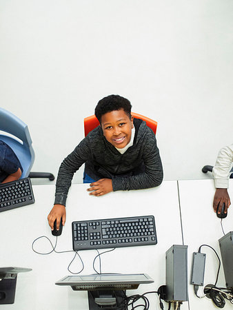 simsearch:6113-09240477,k - Portrait from above confident junior high boy student using computer in computer lab Foto de stock - Royalty Free Premium, Número: 6113-09240346