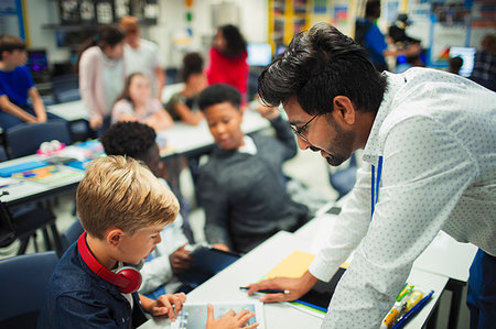 Male teacher helping junior high school boy student using digital tablet in classroom Stock Photo - Premium Royalty-Free, Code: 6113-09240370