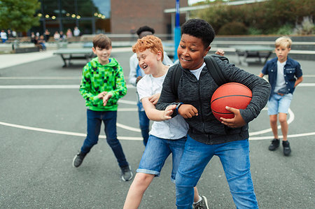 school boys fighting images - Tween boys playing basketball in schoolyard Photographie de stock - Premium Libres de Droits, Code: 6113-09240315