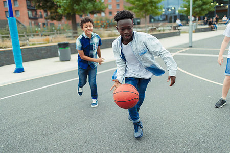 Tween boys playing basketball in schoolyard Stock Photo - Premium Royalty-Free, Code: 6113-09240333