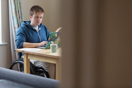 simsearch:649-07648135,k - Young woman in wheelchair using laptop at dining table Stock Photo - Premium Royalty-Free, Code: 6113-09240666