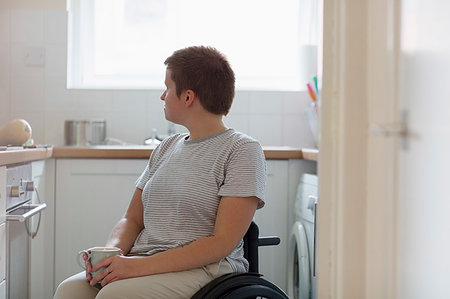 simsearch:6113-07565565,k - Thoughtful young woman in wheelchair drinking tea in apartment kitchen Stock Photo - Premium Royalty-Free, Code: 6113-09240695
