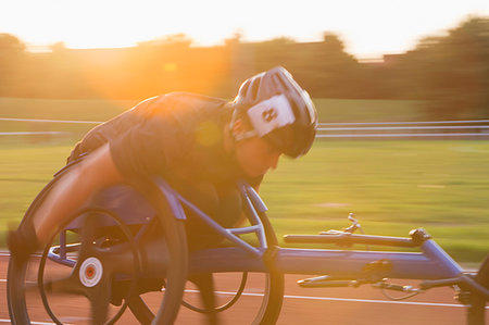 simsearch:6113-09240745,k - Determined young female paraplegic athlete speeding along sports track in wheelchair race Stock Photo - Premium Royalty-Free, Code: 6113-09240612