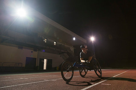 paraplegic helmet - Determined female paraplegic athlete training for wheelchair race on sports track at night Stock Photo - Premium Royalty-Free, Code: 6113-09240771