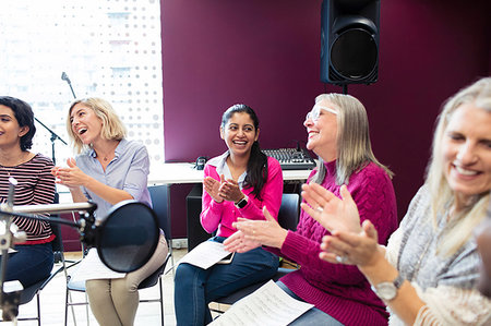 simsearch:6113-09168289,k - Happy womens choir with sheet music singing and clapping in music recording studio Stock Photo - Premium Royalty-Free, Code: 6113-09240891