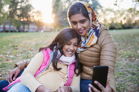 simsearch:6113-08910059,k - Muslim mother in hijab taking selfie with daughter in autumn park Stock Photo - Premium Royalty-Free, Code: 6113-09240962