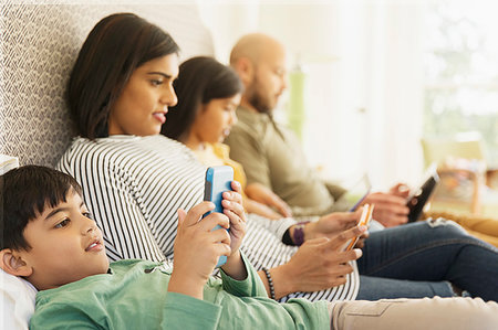 Family using technology on bed Stock Photo - Premium Royalty-Free, Code: 6113-09241045