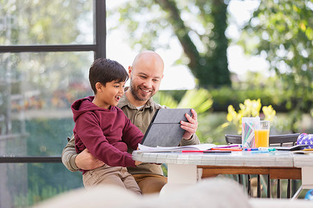 simsearch:6113-09241137,k - Father and son using digital tablet at table Photographie de stock - Premium Libres de Droits, Code: 6113-09241080