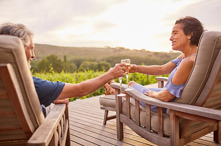 simsearch:6113-07730777,k - Couple relaxing with champagne on resort patio Stock Photo - Premium Royalty-Free, Code: 6113-09241148