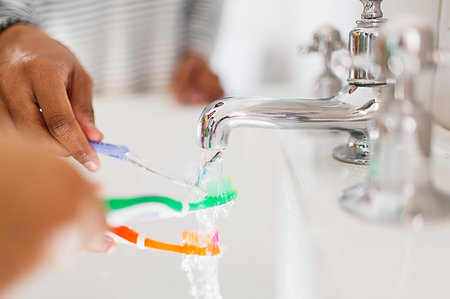 Close up family rinsing toothbrushes in bathroom sink Stock Photo - Premium Royalty-Free, Code: 6113-09241101