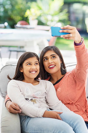 Mother and daughter taking selfie with camera phone Stock Photo - Premium Royalty-Free, Code: 6113-09241105