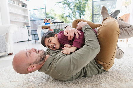 simsearch:6113-09241137,k - Playful father and son hugging on floor Photographie de stock - Premium Libres de Droits, Code: 6113-09241122