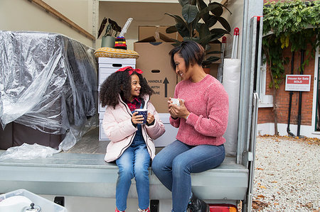 Mother and daughter drinking tea at back of moving van Photographie de stock - Premium Libres de Droits, Code: 6113-09241257