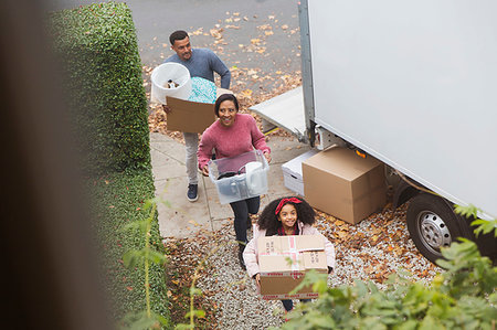 Family moving into new house, carrying boxes from moving van Stock Photo - Premium Royalty-Free, Code: 6113-09241265