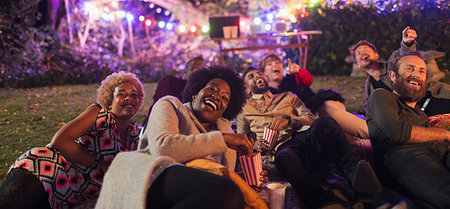 Laughing friends watching movie in backyard Photographie de stock - Premium Libres de Droits, Code: 6113-09241343
