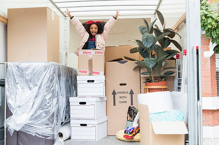 simsearch:649-06533075,k - Portrait playful girl jumping up from behind cardboard boxes in moving van Stock Photo - Premium Royalty-Free, Code: 6113-09241308