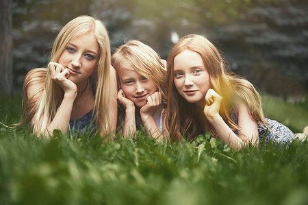 Portrait beautiful sisters laying in grass Stock Photo - Premium Royalty-Free, Code: 6113-09241485