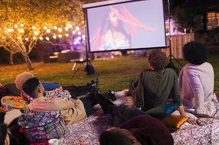 Friends watching movie on projection screen in backyard Photographie de stock - Premium Libres de Droits, Code: 6113-09241426