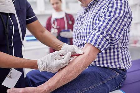 simsearch:400-06476996,k - Female doctor drawing blood from senior male patient in clinic examination room Foto de stock - Royalty Free Premium, Número: 6113-09241598