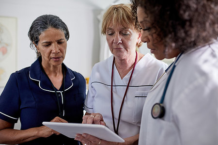 Female doctor and nurses using digital tablet in clinic Stock Photo - Premium Royalty-Free, Code: 6113-09241508