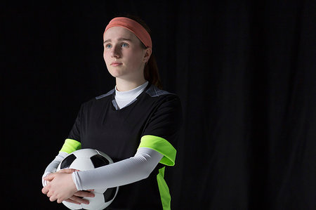 Portrait confident, ambitious teenage girl soccer player holding ball Stock Photo - Premium Royalty-Free, Code: 6113-09272473
