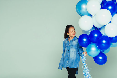 simsearch:633-01992711,k - Smiling girl with blue and white balloon bunch Stock Photo - Premium Royalty-Free, Code: 6113-09272478