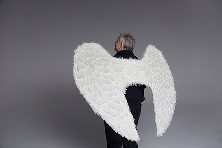 simsearch:6116-08945644,k - Serene man wearing angel wings, looking up Photographie de stock - Premium Libres de Droits, Code: 6113-09272492