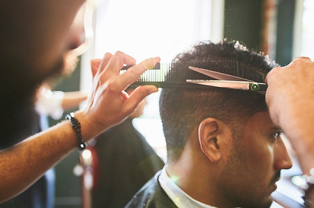 simsearch:6113-08882689,k - Male barber giving customer a haircut in barbershop Stock Photo - Premium Royalty-Free, Code: 6113-09272546