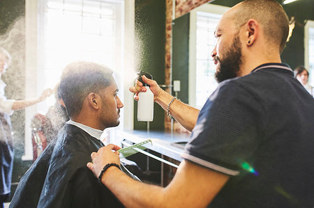 simsearch:6113-08985879,k - Male barber spraying hair of man in barbershop Foto de stock - Royalty Free Premium, Número: 6113-09272551