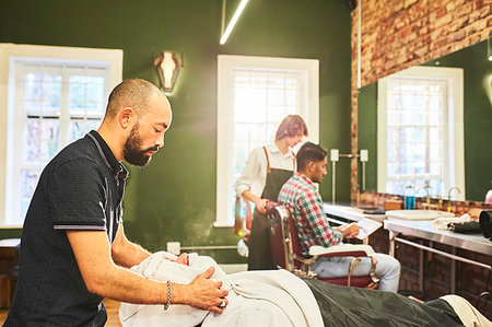 Male barber steaming face of customer in barbershop Foto de stock - Sin royalties Premium, Código: 6113-09272552