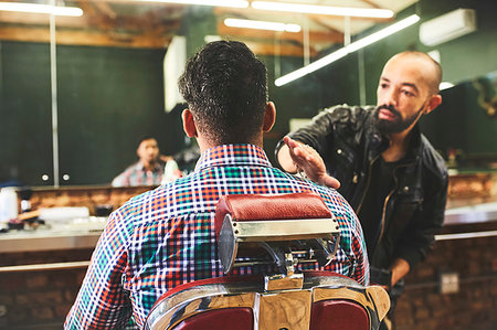 Male barber checking haircut of customer in barbershop Stock Photo - Premium Royalty-Free, Code: 6113-09272558