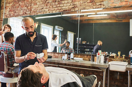 Male barber preparing to shave face of customer in barbershop Stock Photo - Premium Royalty-Free, Code: 6113-09272559