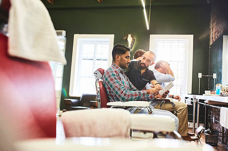 Male barber and customer with digital tablet talking in barbershop Stock Photo - Premium Royalty-Free, Code: 6113-09272575