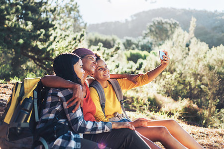 Happy mother and daughters taking selfie, hiking in sunny woods Stock Photo - Premium Royalty-Free, Code: 6113-09272699