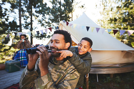 father son camping woods - Happy, curious father and son with binoculars at campsite Stock Photo - Premium Royalty-Free, Code: 6113-09272761