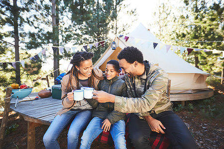 Happy family drinking coffee and hot chocolate at campsite in woods Stock Photo - Premium Royalty-Free, Code: 6113-09272777