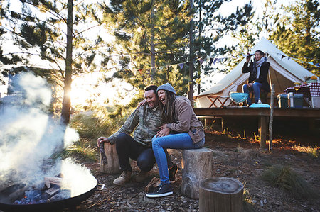 simsearch:6113-07564897,k - Happy couple sitting at campsite campfire in woods Photographie de stock - Premium Libres de Droits, Code: 6113-09272791