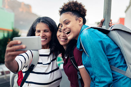 simsearch:6113-08947395,k - Happy mother and daughters backpacking, taking selfie with camera phone Stock Photo - Premium Royalty-Free, Code: 6113-09272706