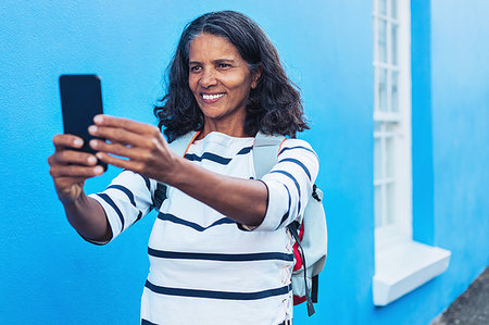simsearch:6113-08743400,k - Happy female tourist taking selfie with smart phone Photographie de stock - Premium Libres de Droits, Code: 6113-09272717