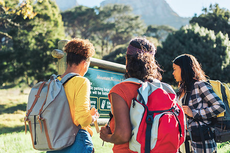 simsearch:6124-09269482,k - Female hikers looking at sign in sunny woods Fotografie stock - Premium Royalty-Free, Codice: 6113-09272738