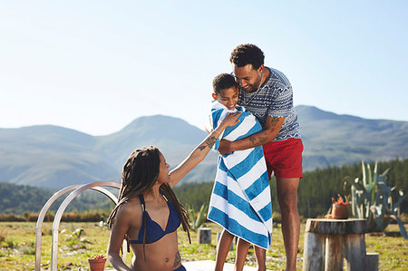 swimsuit mother hugs son - Happy, affectionate family at remote, sunny, summer poolside Stock Photo - Premium Royalty-Free, Code: 6113-09272814