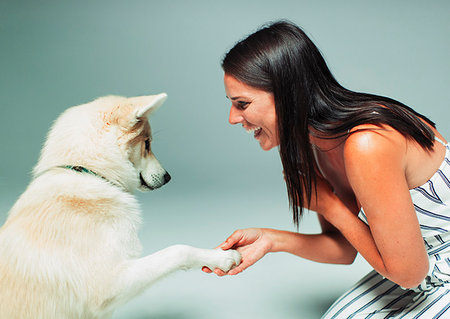 simsearch:649-08125927,k - Smiling woman shaking dogs paw Photographie de stock - Premium Libres de Droits, Code: 6113-09200009