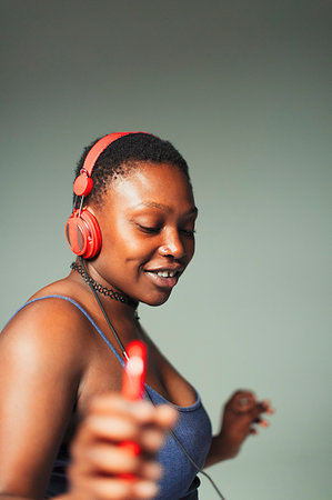 simsearch:6113-08105413,k - Carefree young woman with headphones and mp3 player dancing Foto de stock - Royalty Free Premium, Número: 6113-09200112
