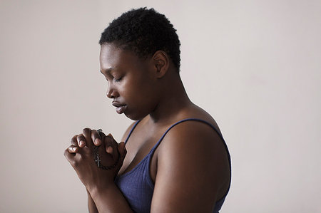 Portrait serene woman with rosary praying Stock Photo - Premium Royalty-Free, Code: 6113-09200118