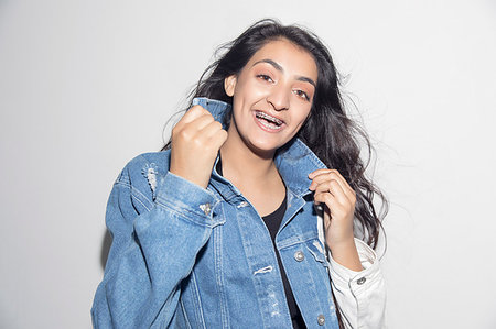 simsearch:6113-09220464,k - Portrait happy, confident teenage girl with braces wearing denim jacket Foto de stock - Sin royalties Premium, Código: 6113-09220442