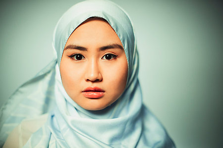 Portrait confident, serious young woman wearing blue silk hijab Stock Photo - Premium Royalty-Free, Code: 6113-09220437