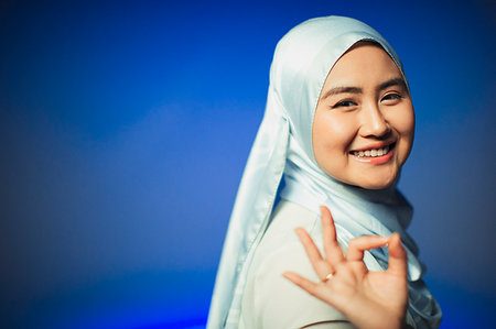 Portrait smiling, confident young woman in hijab gesturing OK Stock Photo - Premium Royalty-Free, Code: 6113-09220541