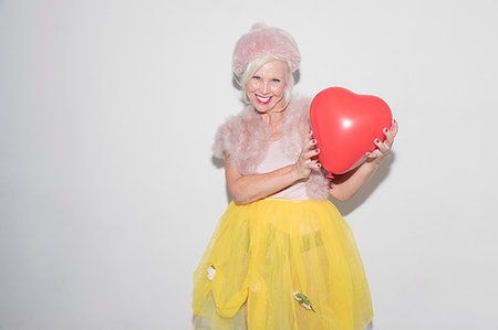 senior energy - Portrait smiling, confident senior woman holding heart-shape balloon Foto de stock - Sin royalties Premium, Código: 6113-09220552