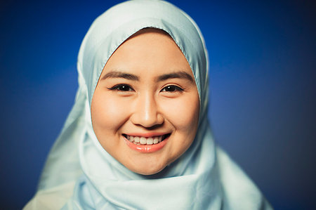 Close up portrait smiling, confident young woman wearing blue silk hijab Stock Photo - Premium Royalty-Free, Code: 6113-09220560