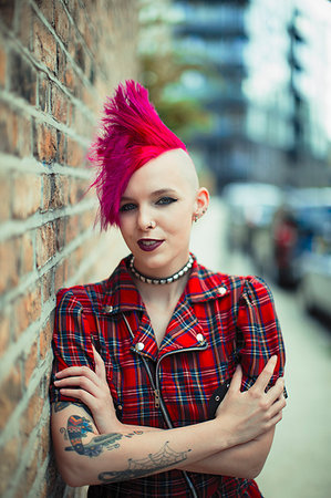 Portrait confident young woman with pink mohawk on urban sidewalk Stock Photo - Premium Royalty-Free, Code: 6113-09220567